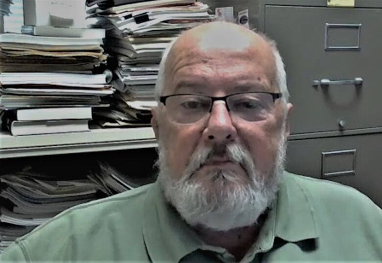 Jim Sentance in office with files in background.