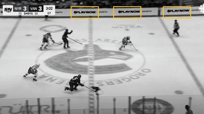 A broadcast view of a hockey game. Three logos are highlighted on the boards, all for a gambling operator called Playnow.