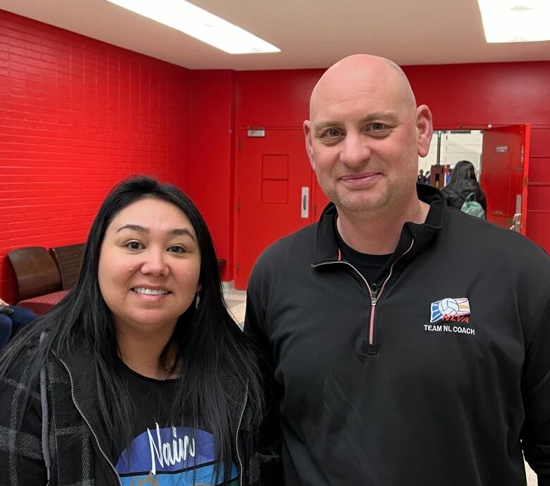 A woman and a man stand next to each other and smile.