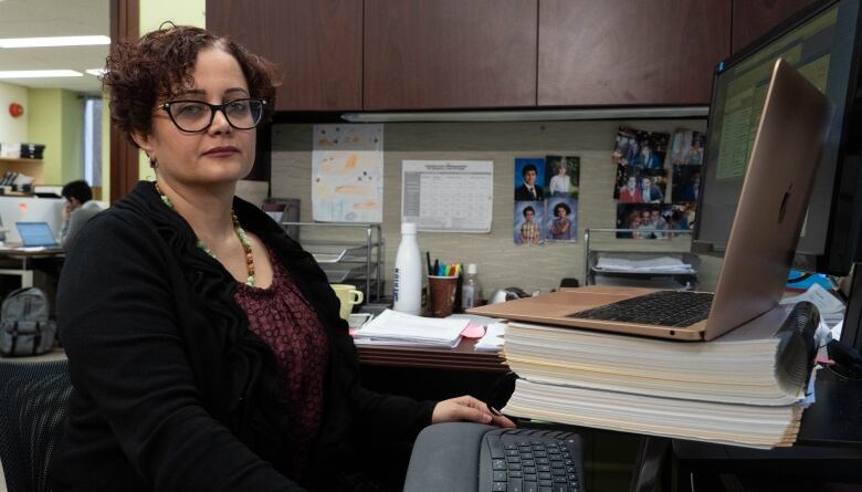 A lawyer poses for a photo at her desk.