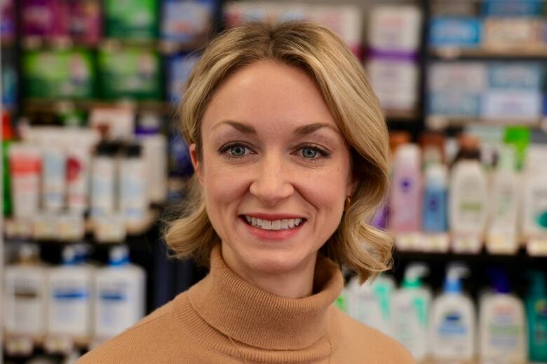 A woman wears a beige turtleneck.