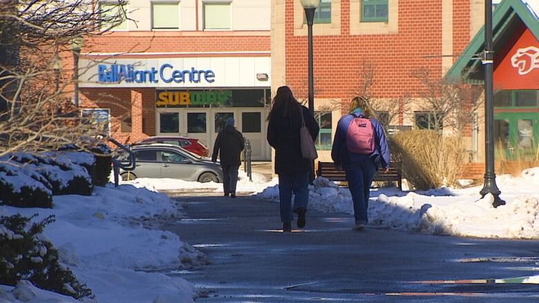 Students walking toward brick building.