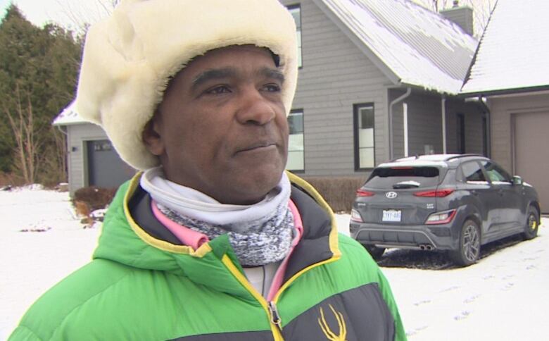 Fayard Johnson standing in front of his house.