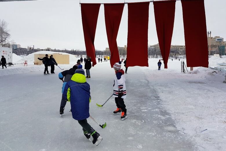 People skate outside on a frozen river trail