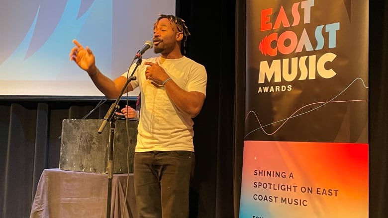 Sea Ruth on stage with East Coast Music Awards sign behind him.