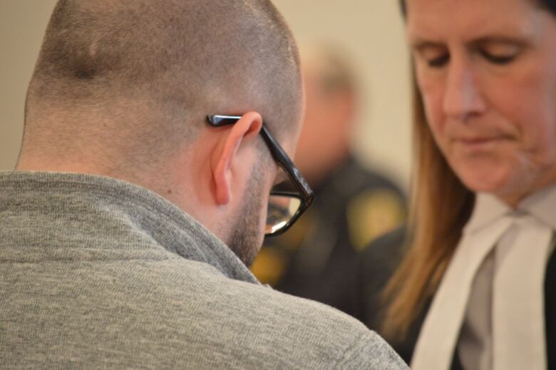 Back of man's head with lawyer blurred in background