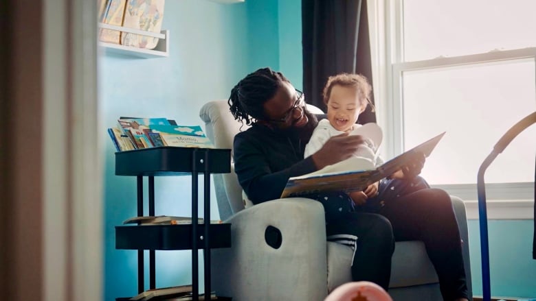 Moses Latigo Odida reads with his four-year-old daughter, Selah, who lives with Down Syndrome.