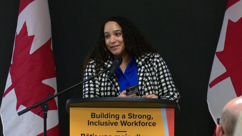 A woman stands at a podium