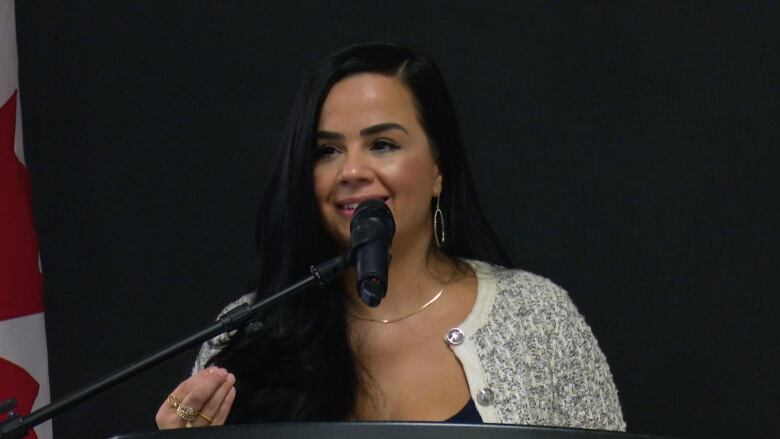 A woman speaks into a podium