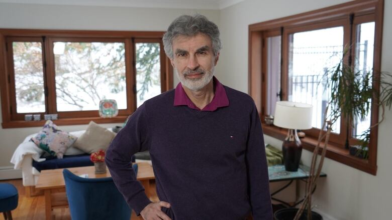 A man looks into the camera from his home.