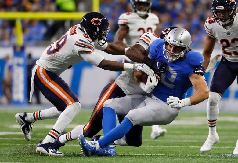 Detroit Lions tight end Luke Willson is tackled by Chicago Bears inside linebacker Roquan Smith and free safety Eddie Jackson (39) during the first half of an NFL football game, Thursday, Nov. 22, 2018, in Detroit.