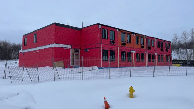 a red building, with snow underneath