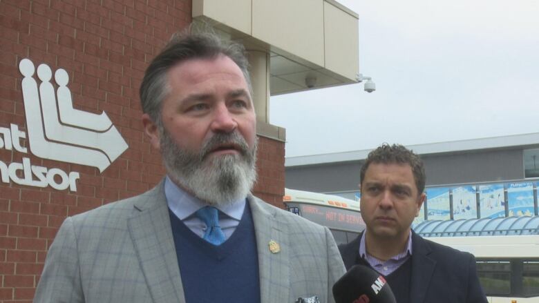 Kieran McKenzie stands beside Fabio Costante in front of the Transit Windsor terminal. 