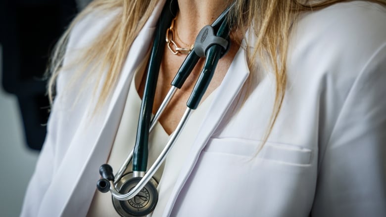 A stethoscope drapes around a female doctor's neck