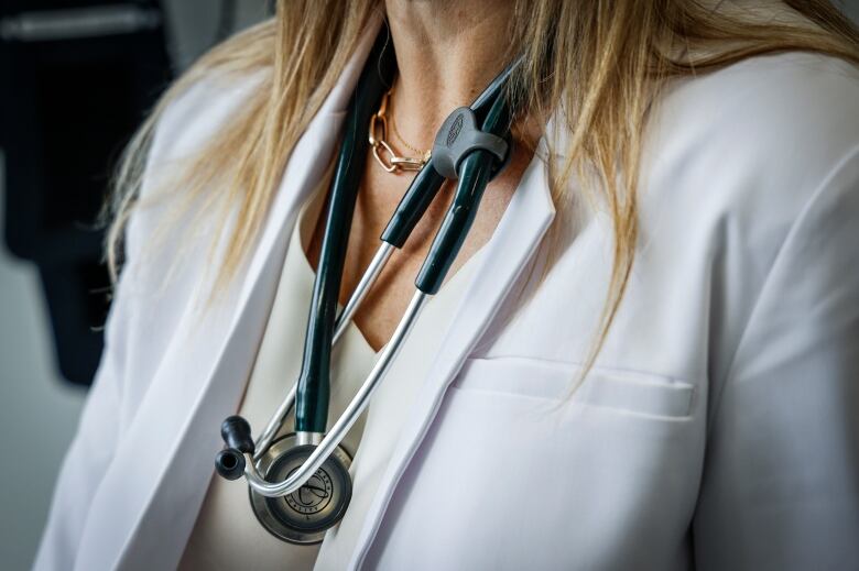 A stethoscope drapes around a female doctor's neck