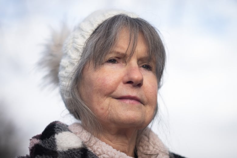 An older white woman wearing a toque smiles.