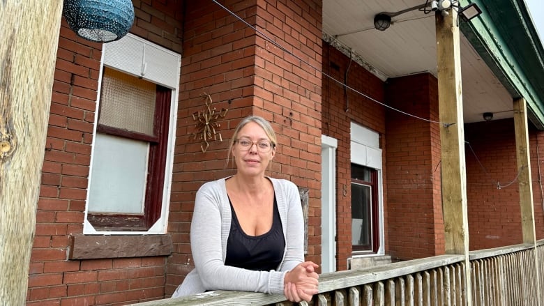 woman stands at balcony