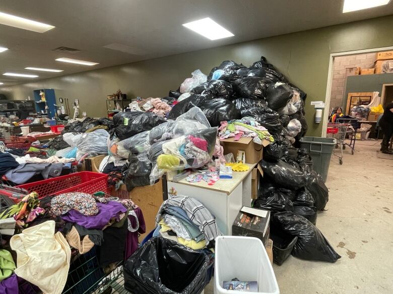 A large pile of garbage bags filled with clothing.