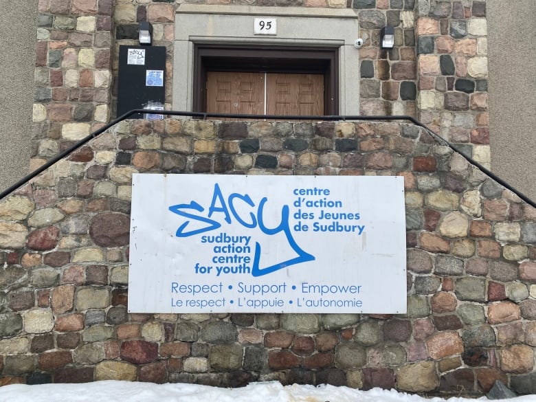 The front of a stone building with a sign that says Sudbury Action Centre for Youth.