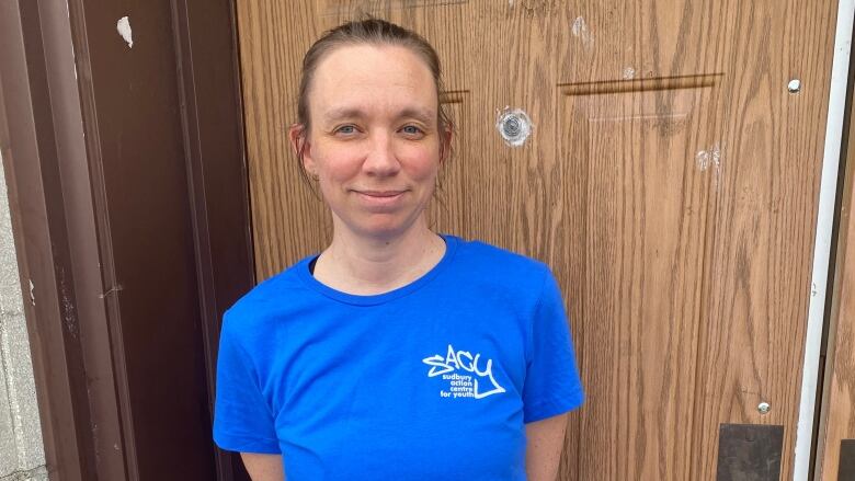 A woman wearing a blue t-shirt.