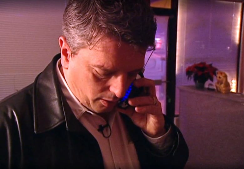 James Fisher talks into a flip phone inside a massage parlour.