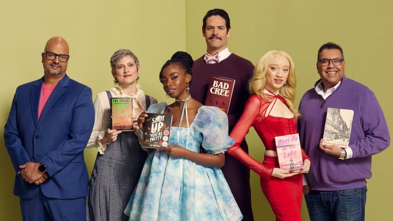 A bald brown man in a blue suit stands next to others with books, a white woman in overalls, a Black woman in a dress, a Cree man, a Black woman with albinism, a brown man in purple. 