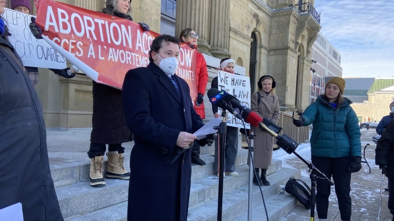 Adrian Edgar address people outside the New Brunswick Legislature.