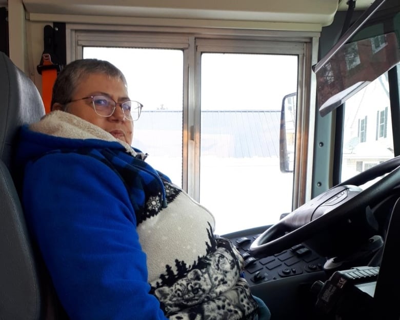 Woman sitting in driver's seat of a school bus