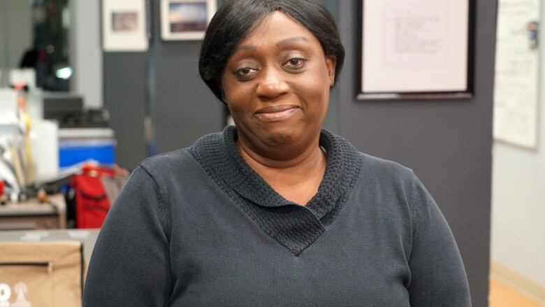 A woman wearing a black long-sleeved shirt in an office.