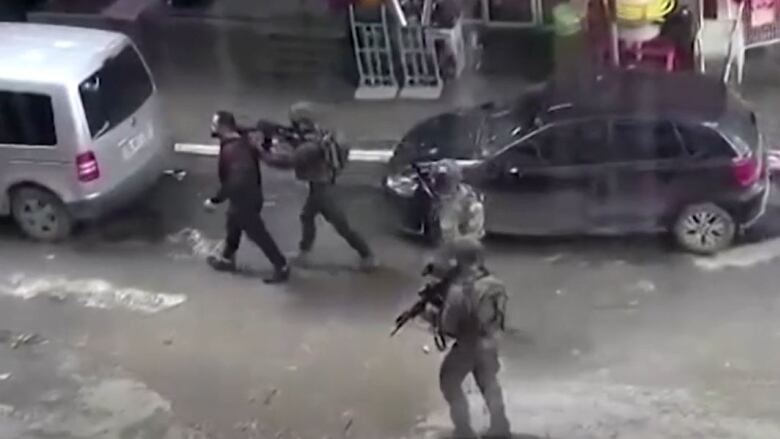 Cellphone store owner Baha Abu Ras is seen here in cellphone footage being used as a human shield by Israeli soldiers in the town of Dura, in the West Bank, on January 15. Abu Ras was later released unharmed, although two Palestinians were shot dead in the Israeli raid.