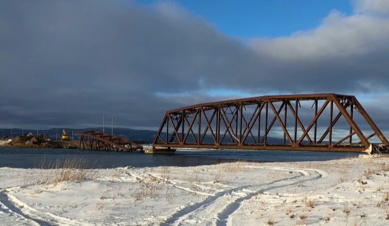 A broken bridge collapsing into the ocean. 