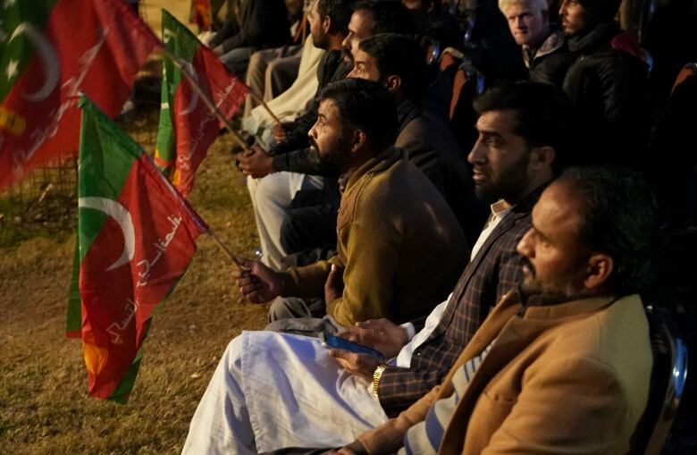 People sit and wave political flags.