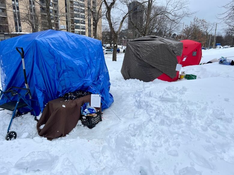 Three tents in a park in snow are shown.