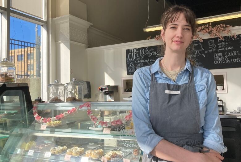 Woman standing in front of a cake display case