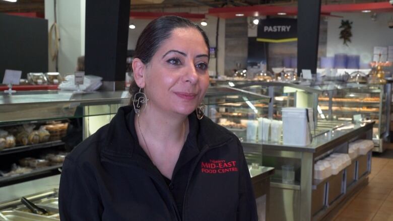 A woman standing in front of a buffet in a store. 