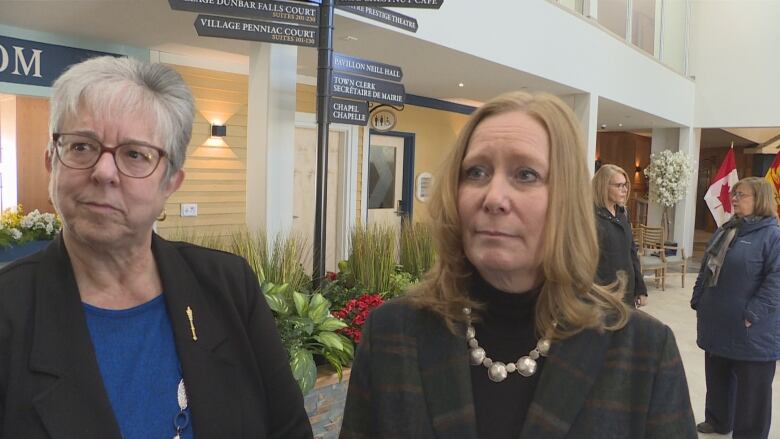 Kathy Bockus, minister responsible for seniors, and Housing Minister Jill Green standing in the foyer of a nursing home.