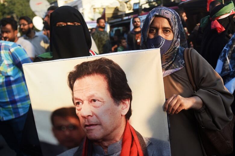 Supporters of the Pakistan Tehreek-e-Insaf (PTI) party hold a picture of jailed former prime minister Imran Khan during a protest outside an election commission office in Karachi on February 10, 2024, amid claims the election result delay is allowing authorities to rig the vote-counting.