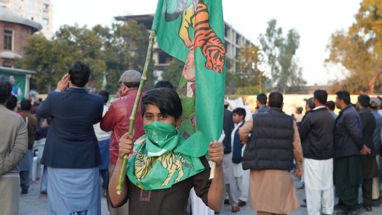 A young boy holds a flag supporting the Pakistan Muslim League (PMLN) party in Islamabad, Pakistan. 