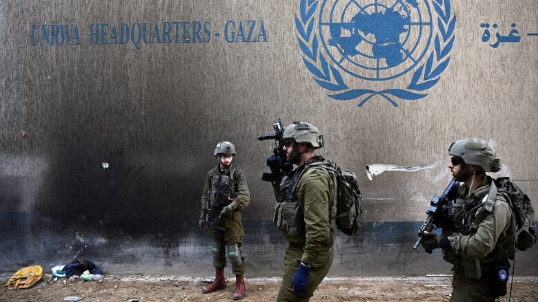 Israeli soldiers are seen near the exterior of the UNRWA headquarters in Gaza City, in the Gaza Strip.