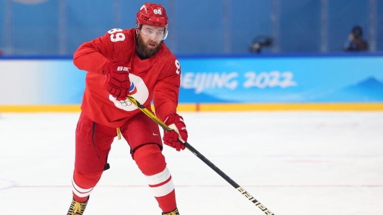 Men's hockey player passes the puck.