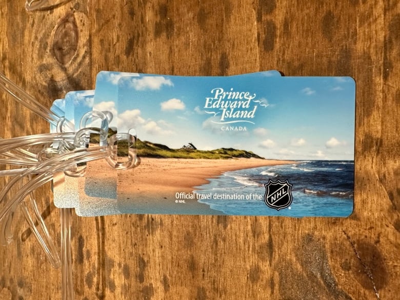 A tag depicting P.E.I. scenery with the NHL logo and Tourism P.E.I. logo with the words official travel destination.