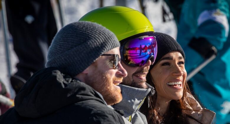 Harry and Megan pose for a photo with a skier