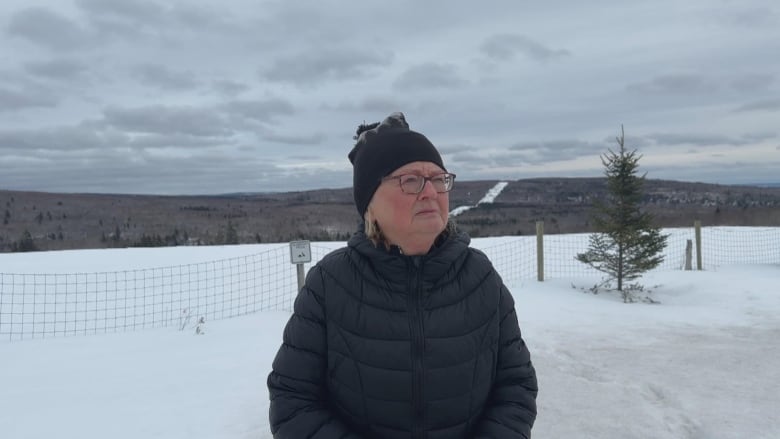 a woman looks at the camera in a snowy field 