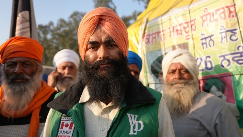 A farmer poses for a photo amid a crowd of fellow protesting farmers. 