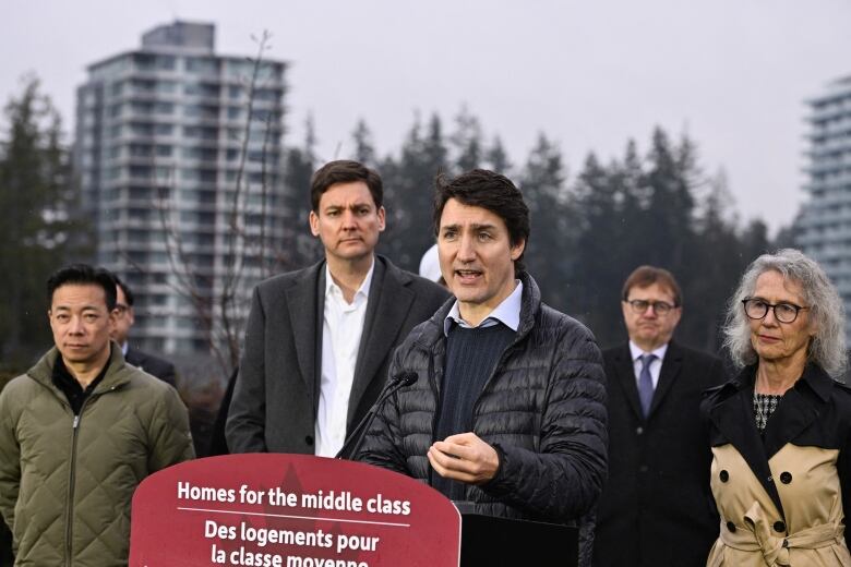 A group of people stand behind a podium