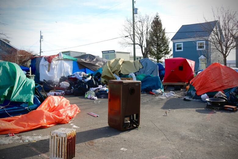 A tent encampment with an old radiator sitting in the middle. 