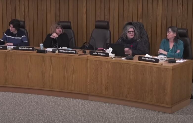 Four trustees sitting at a desk