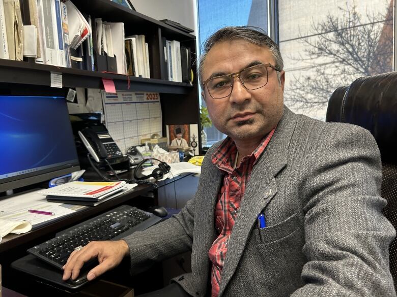 A man sits at his computer in an office.