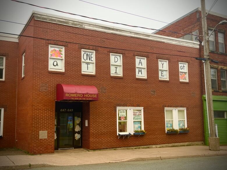 A brick soup kitchen with handmade signs in the windows. 