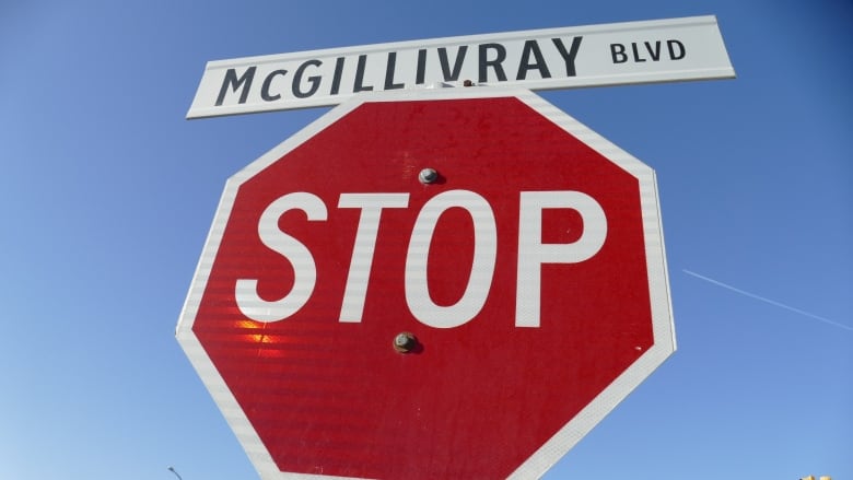 A stop sign with a street sign for McGillivray Boulevard on top.